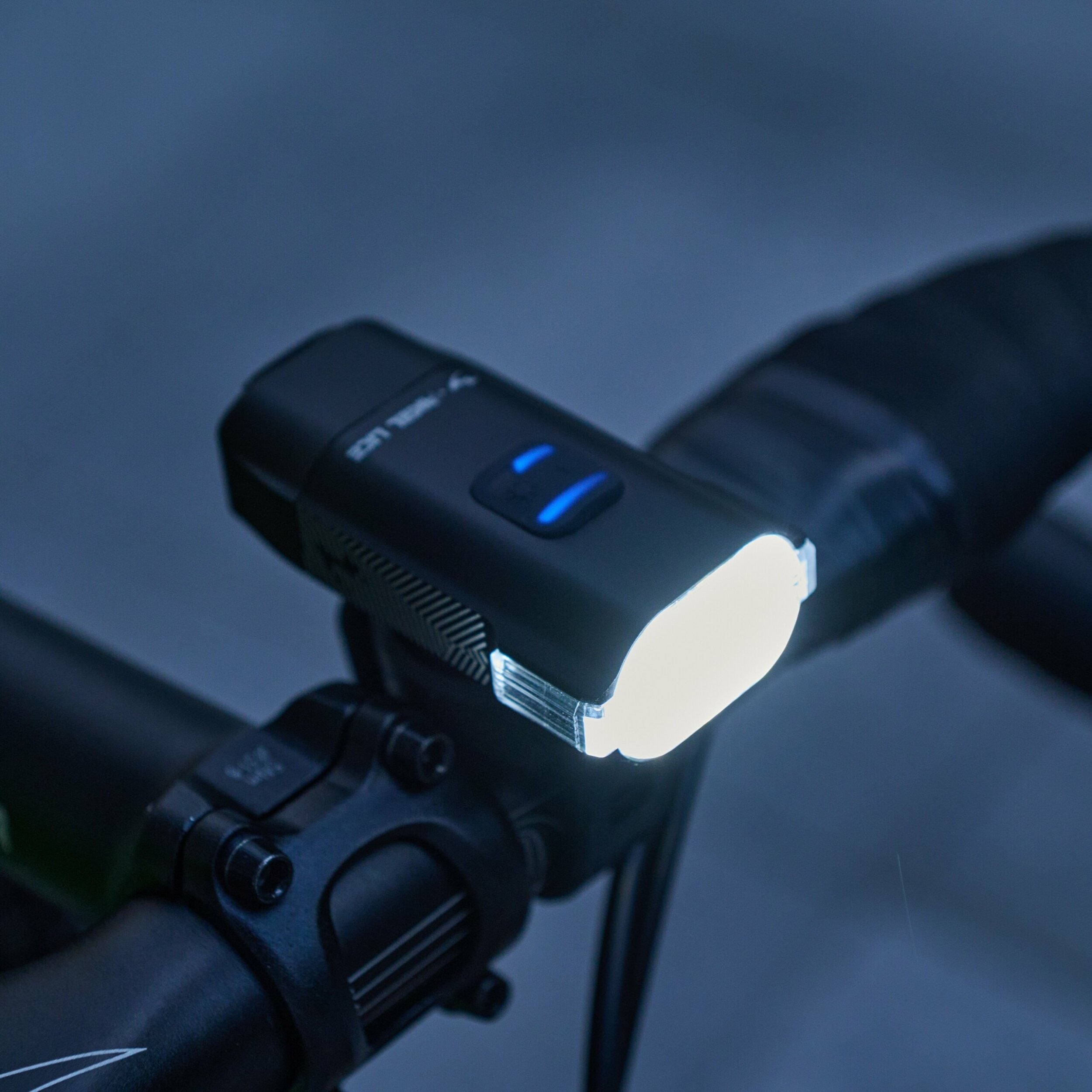 Bicycle light attached to handlebars with a dark background