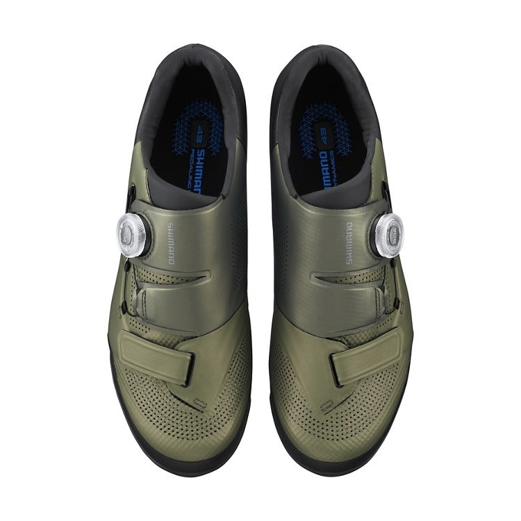 Pair of green cycling shoes with a white background