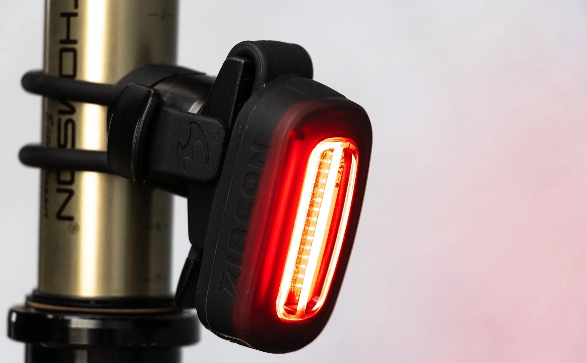 Bicycle tail light attached to a bike frame with a blurred background