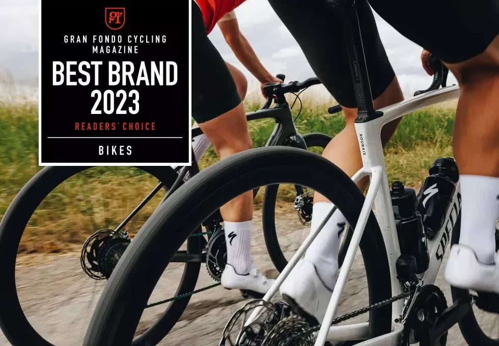 Two cyclists on Specialized Road Bikes with a 'Best Brand 2023'Gran Fondo Cycling Magazine' badge overlay.