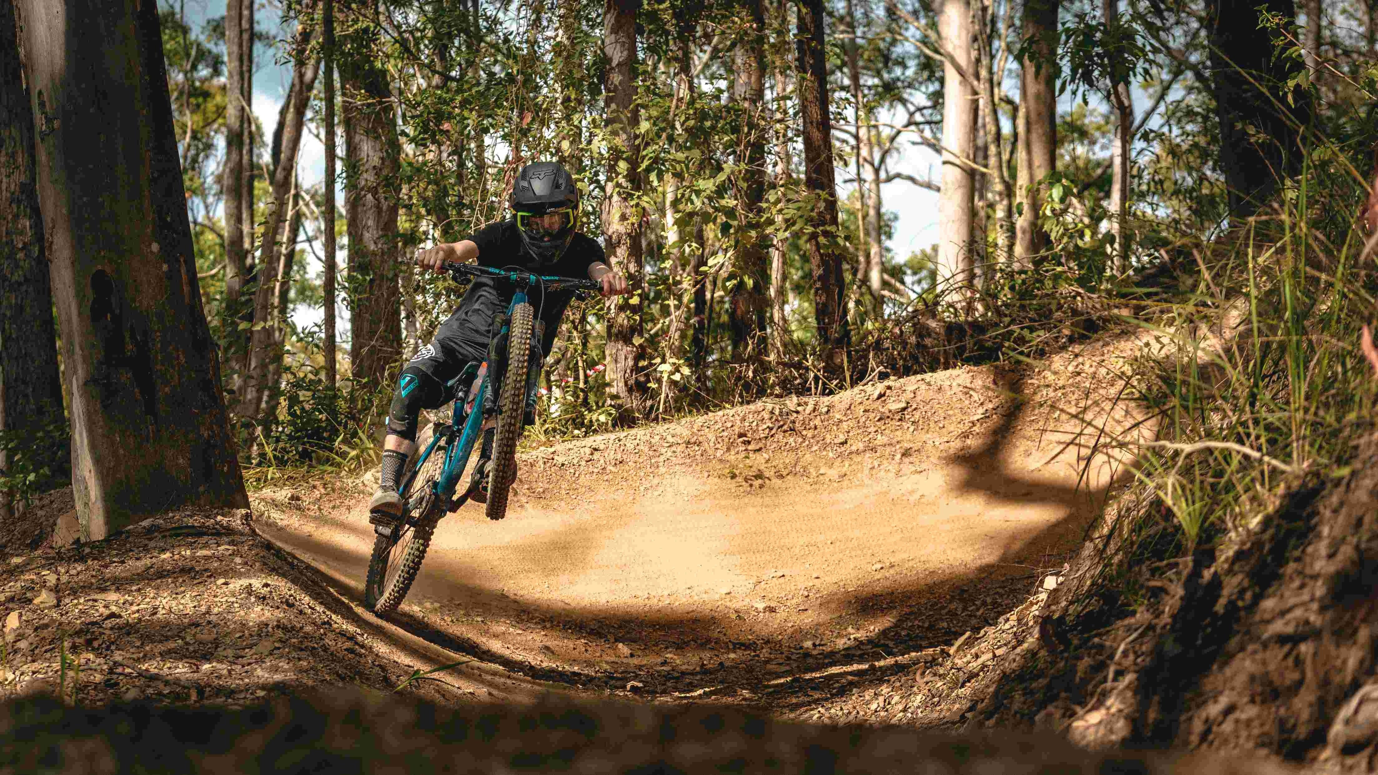 Person riding a mountain bike on a dirt trail in a forest