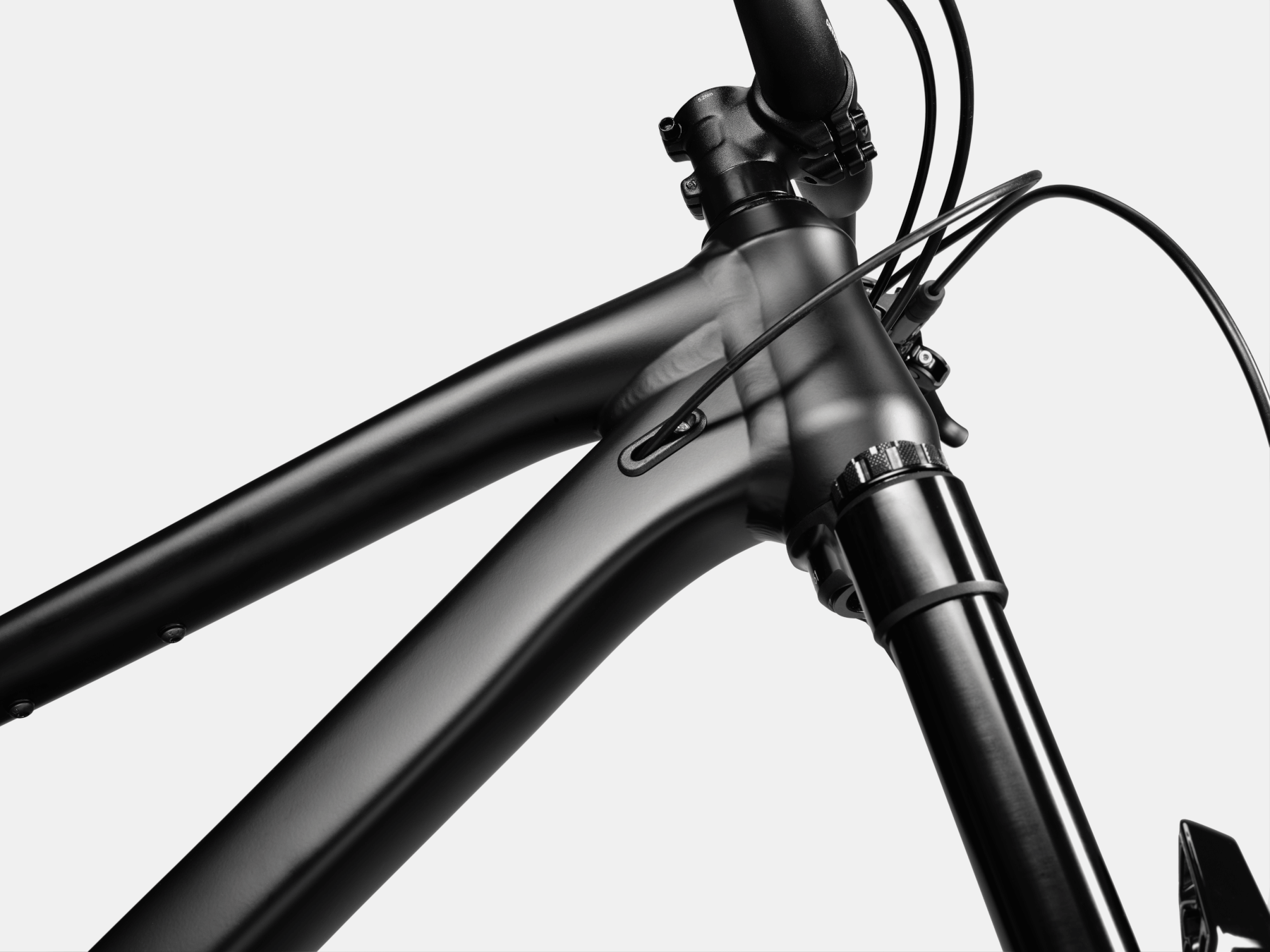 Close-up of a mountain bike frame showing showing part of the frame and the front fork on a white background