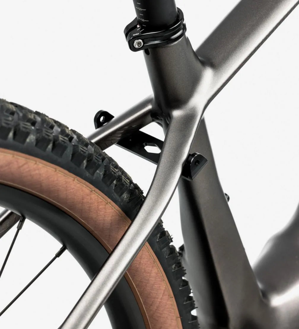Close-up of a silver mountain bike frame and wheel on a white background