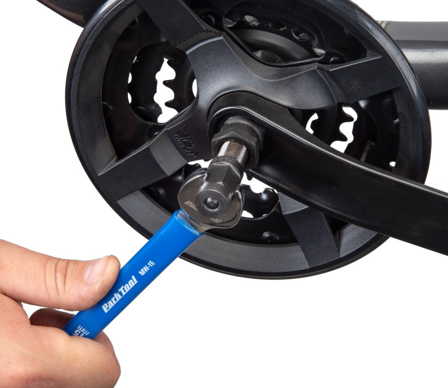 Bicycle crankset with a hand using a blue tool on a white background
