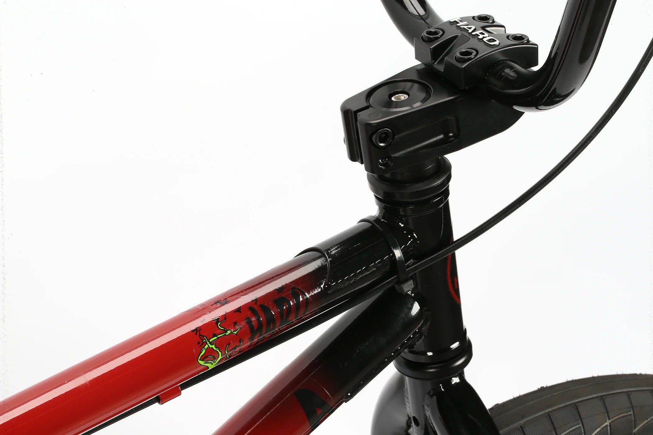Close-up of a red bmx bike frame with black components on a white background