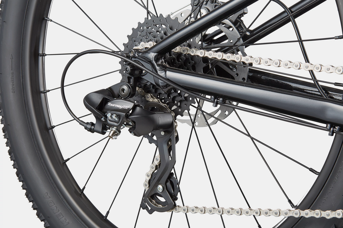 Close up of the rear derailleur on a black kids mountain bike on a white background