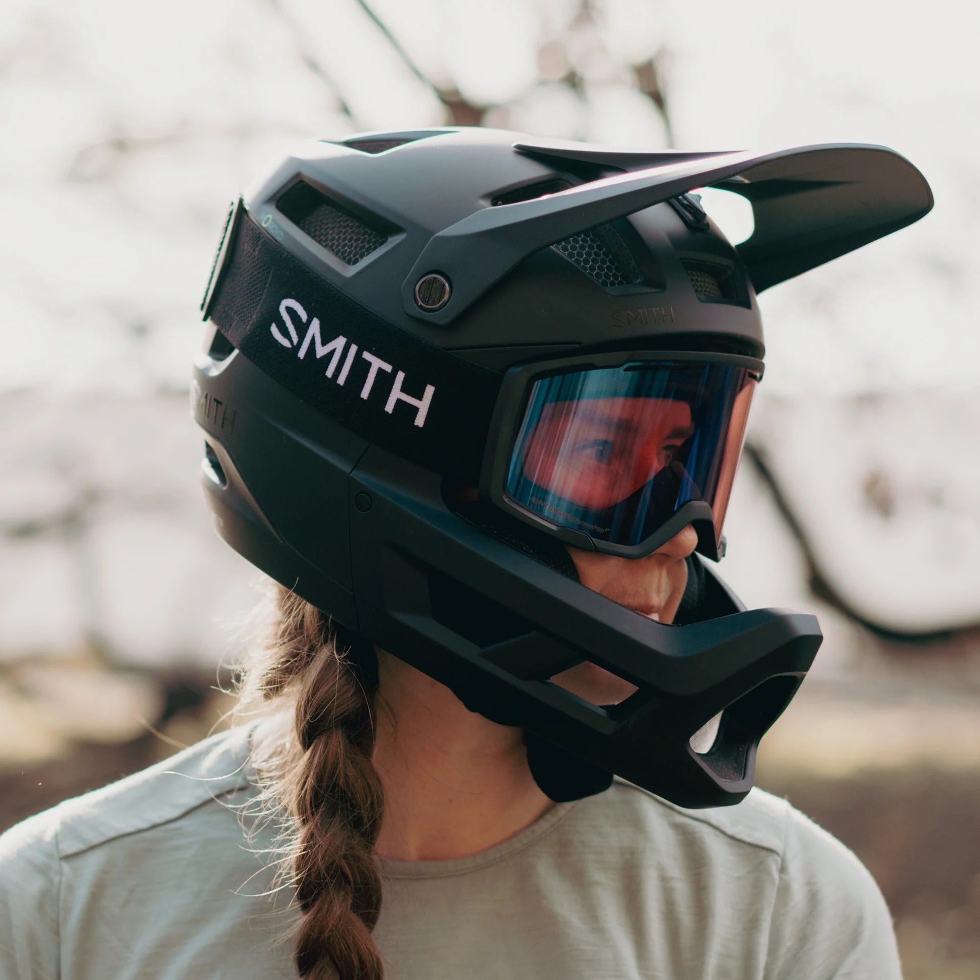 Person wearing a black Smith full face mountain bike helmet with goggles outdoors
