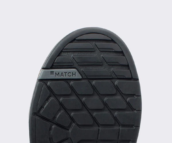 Close-up of a black mountain bike flat shoe sole with a light gray background