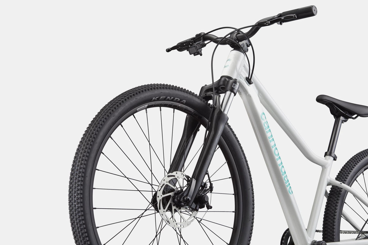 White mountain bike with the 'Cannondale' brand printed in turquoise printed on the downtube on a white background
