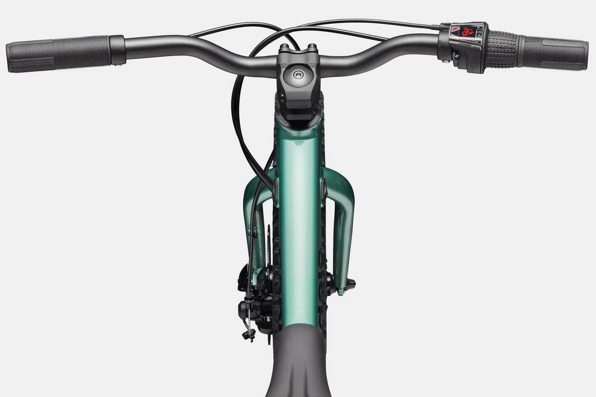 A close up of the handlebar and top tube of a green kids mountain bike on a white background
