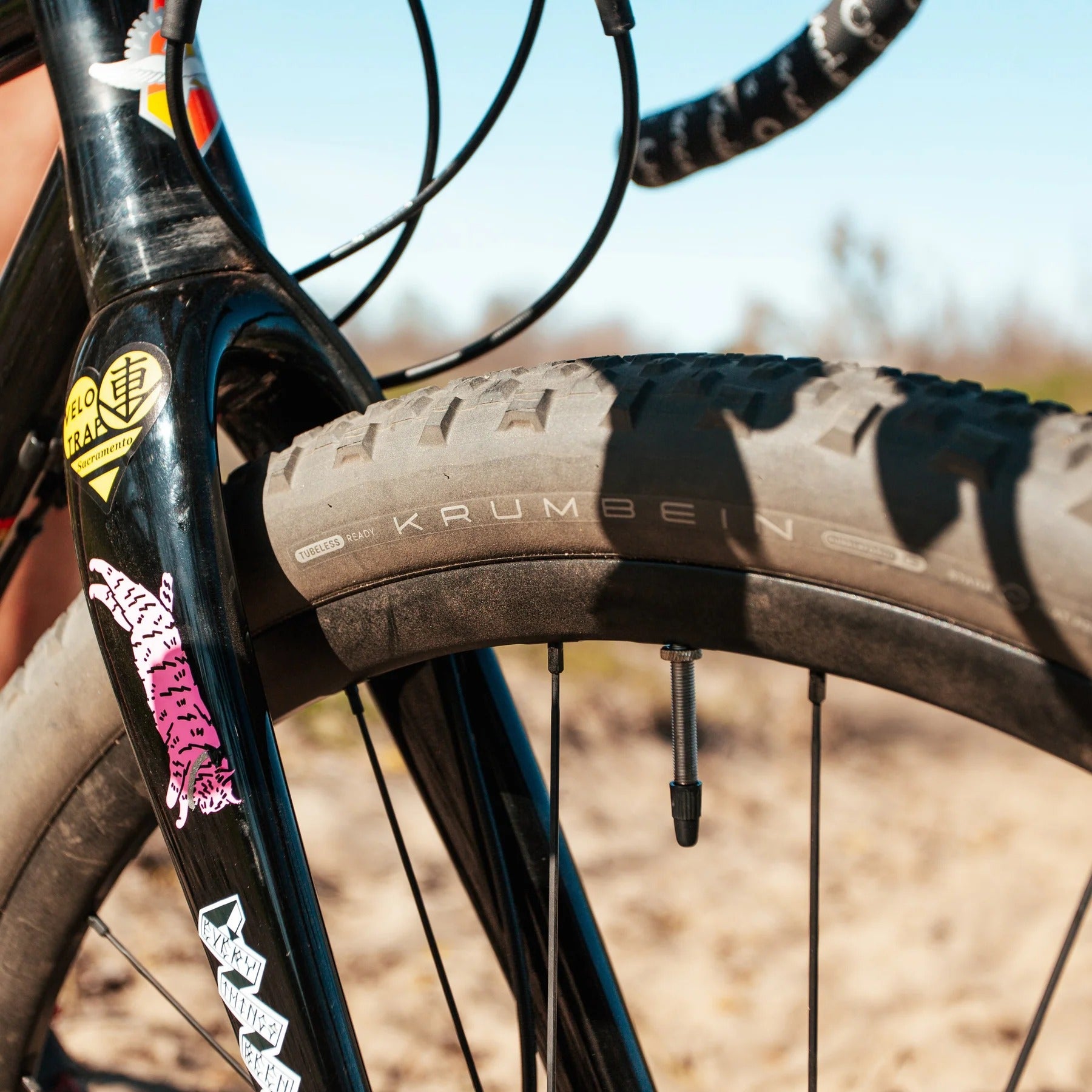 Close-up of a bicycle tyre with 'Krumbein' branding, blurred natural background