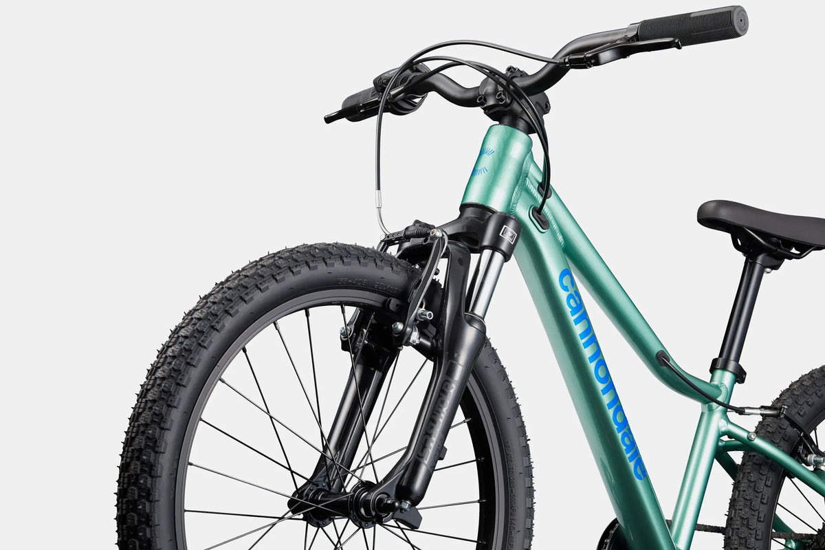 A green Cannondale kids mountain bike on a white background