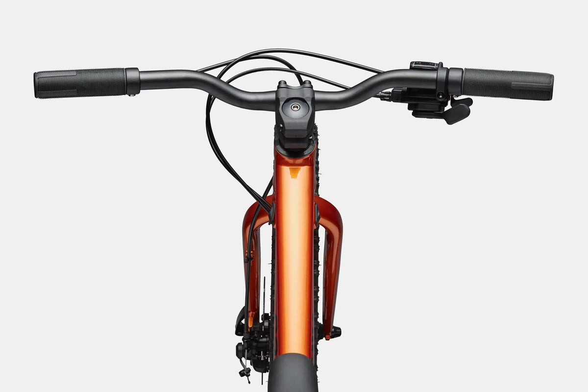 Close up of the handlebars and top tube of an orange mountain bike on a white background