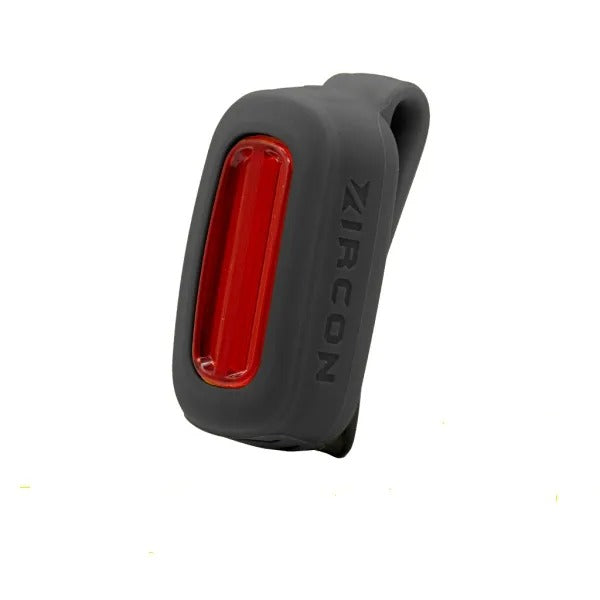 Black rear bicycle light with red light on a white background