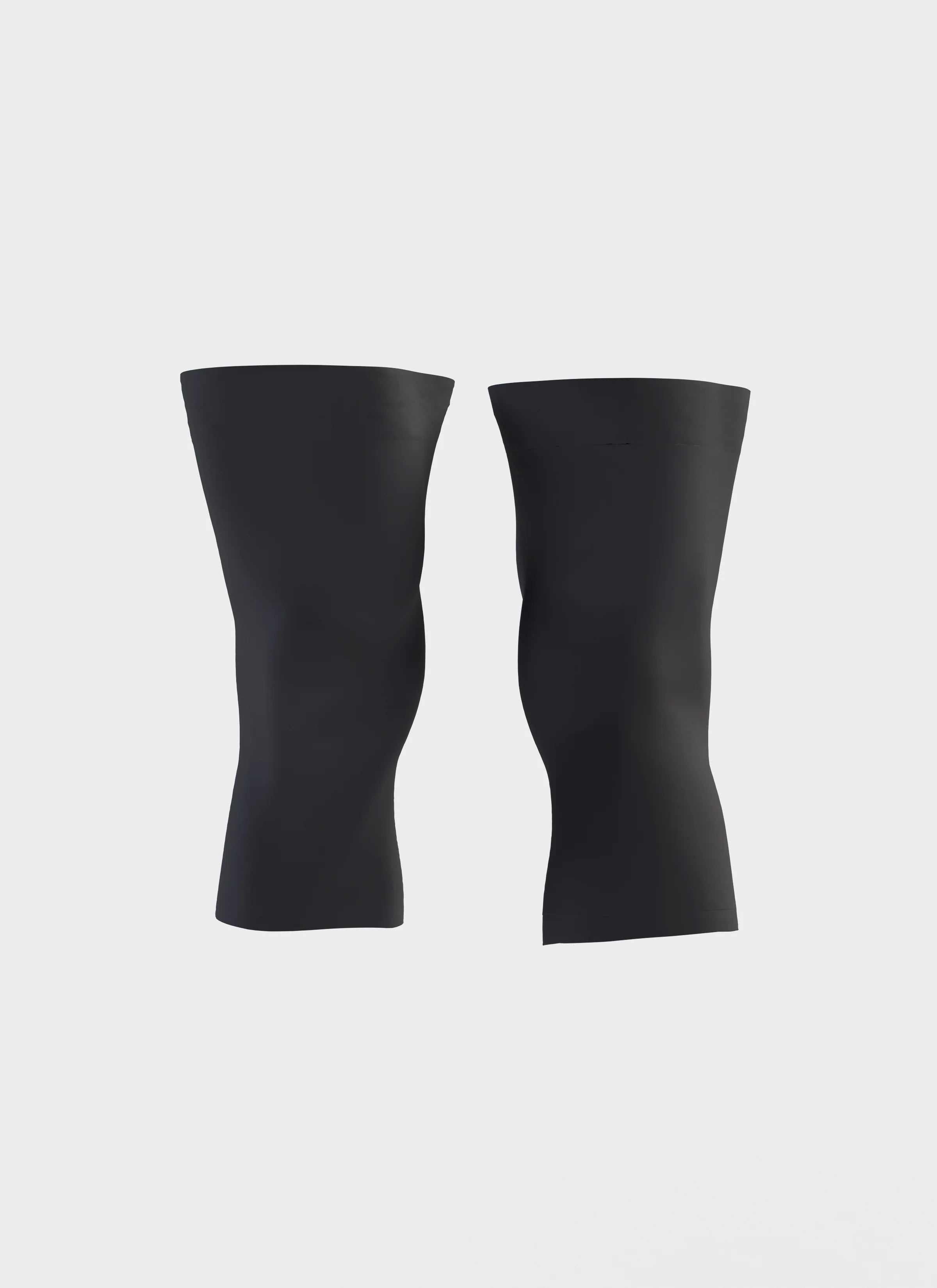 Pair of black cycling knee sleeves on a light gray background