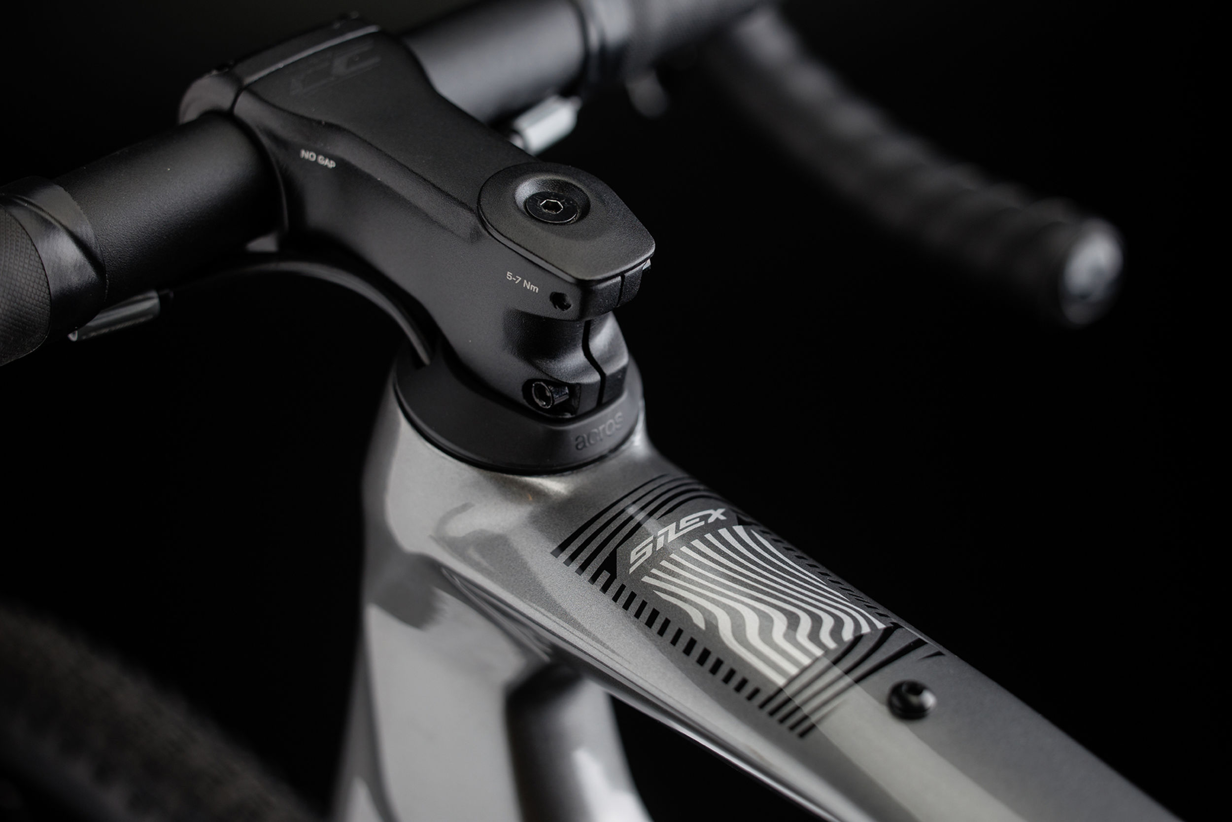 Close-up of a Merida Silex Gravel Bike handlebar with a brand logo on a dark background
