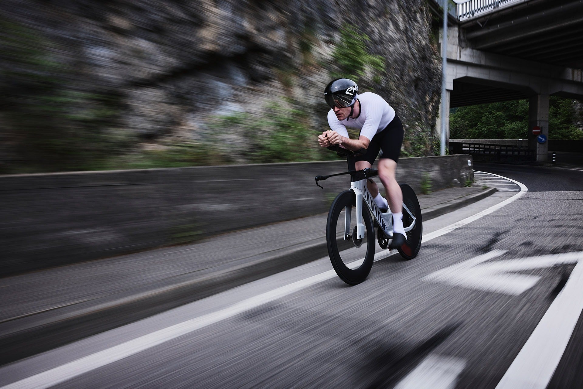 Person riding a bicycle on a road with a mountainous background