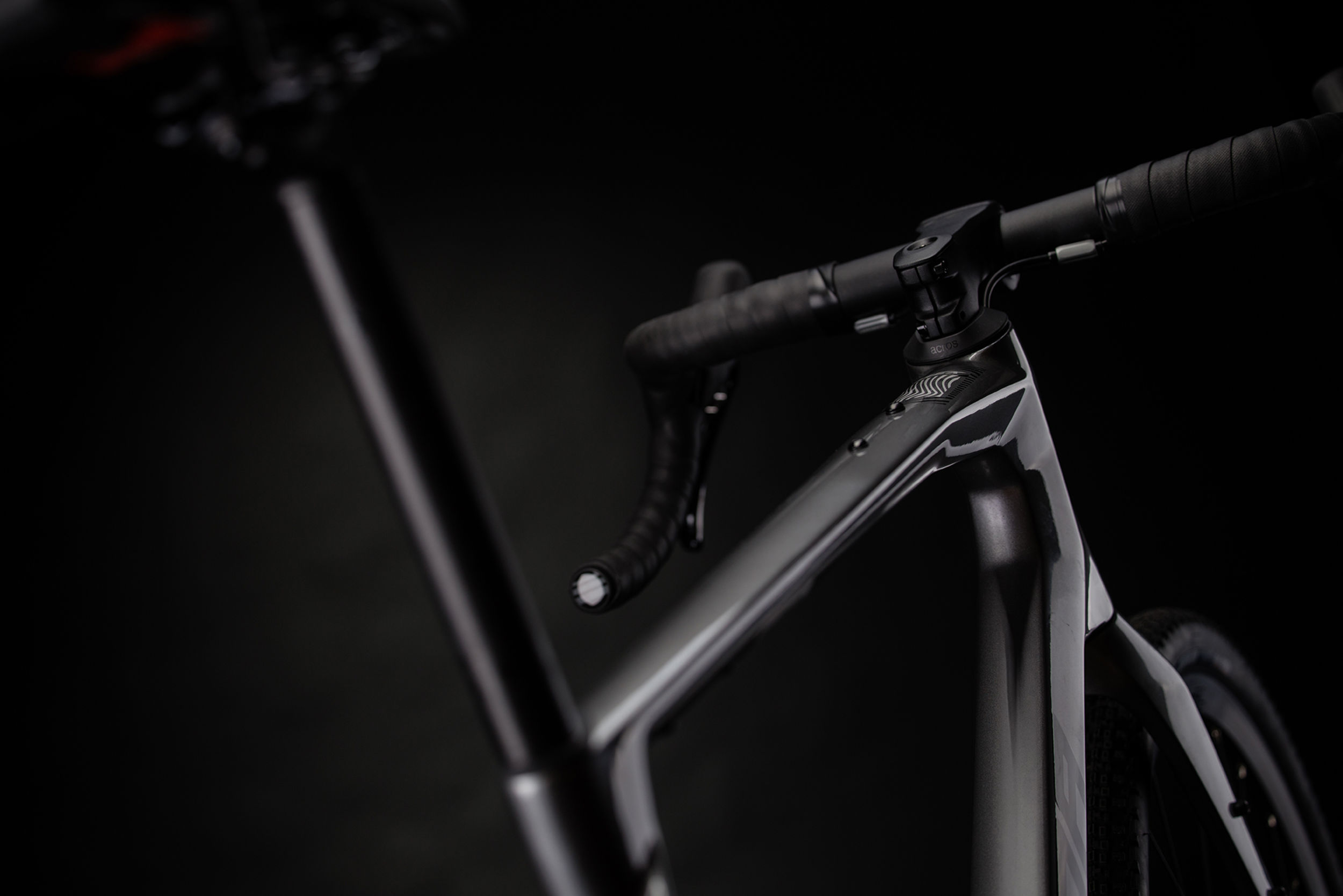Close-up of a grey gravel bike handlebar with dark background