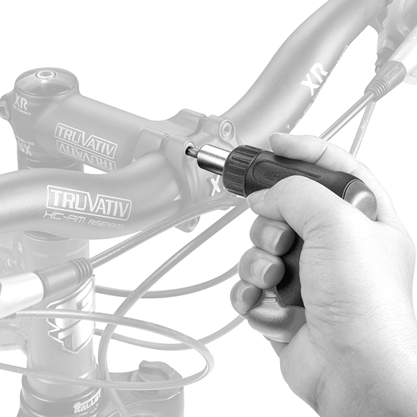 A hand using a preset Torque Wrench on a bike handlebars