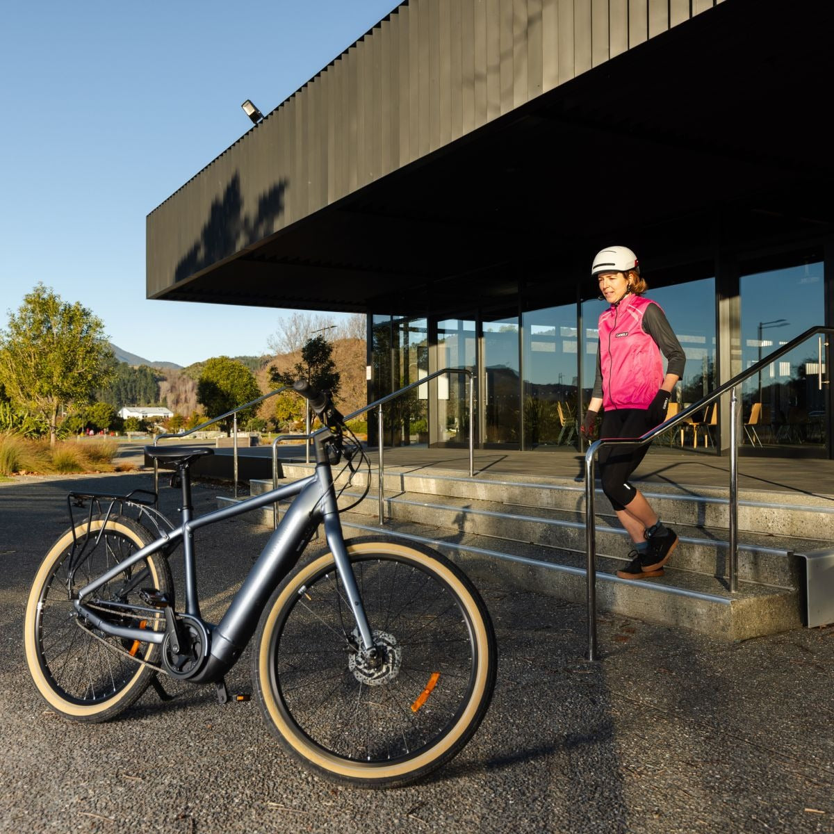 Person with a bicycle near a modern building
