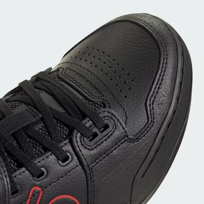 Close up of the shoe area of a black Mountain Bike Shoe with red highlights on a white Background