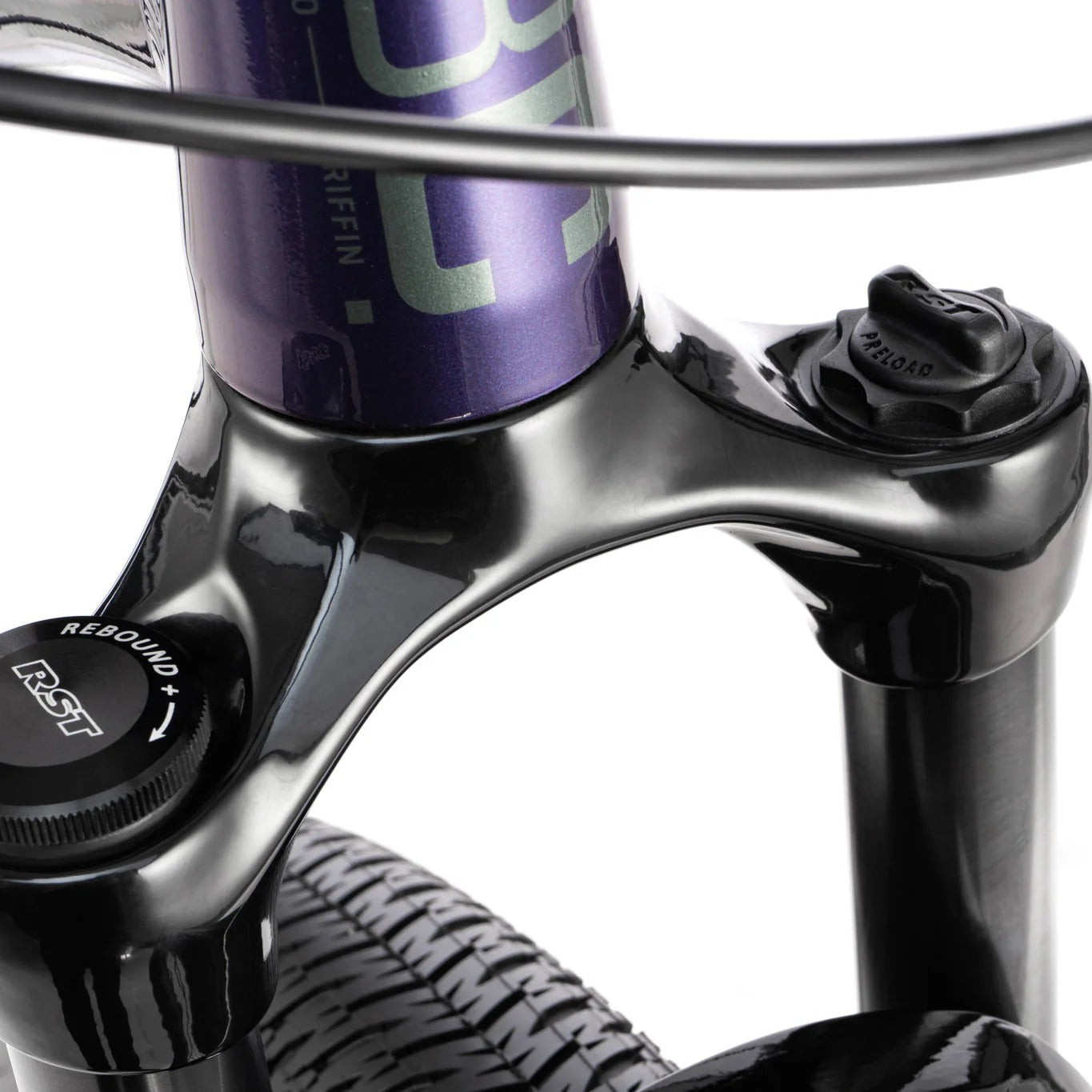 Close-up of a bicycle suspension fork with purple top tube and black components on a white background.