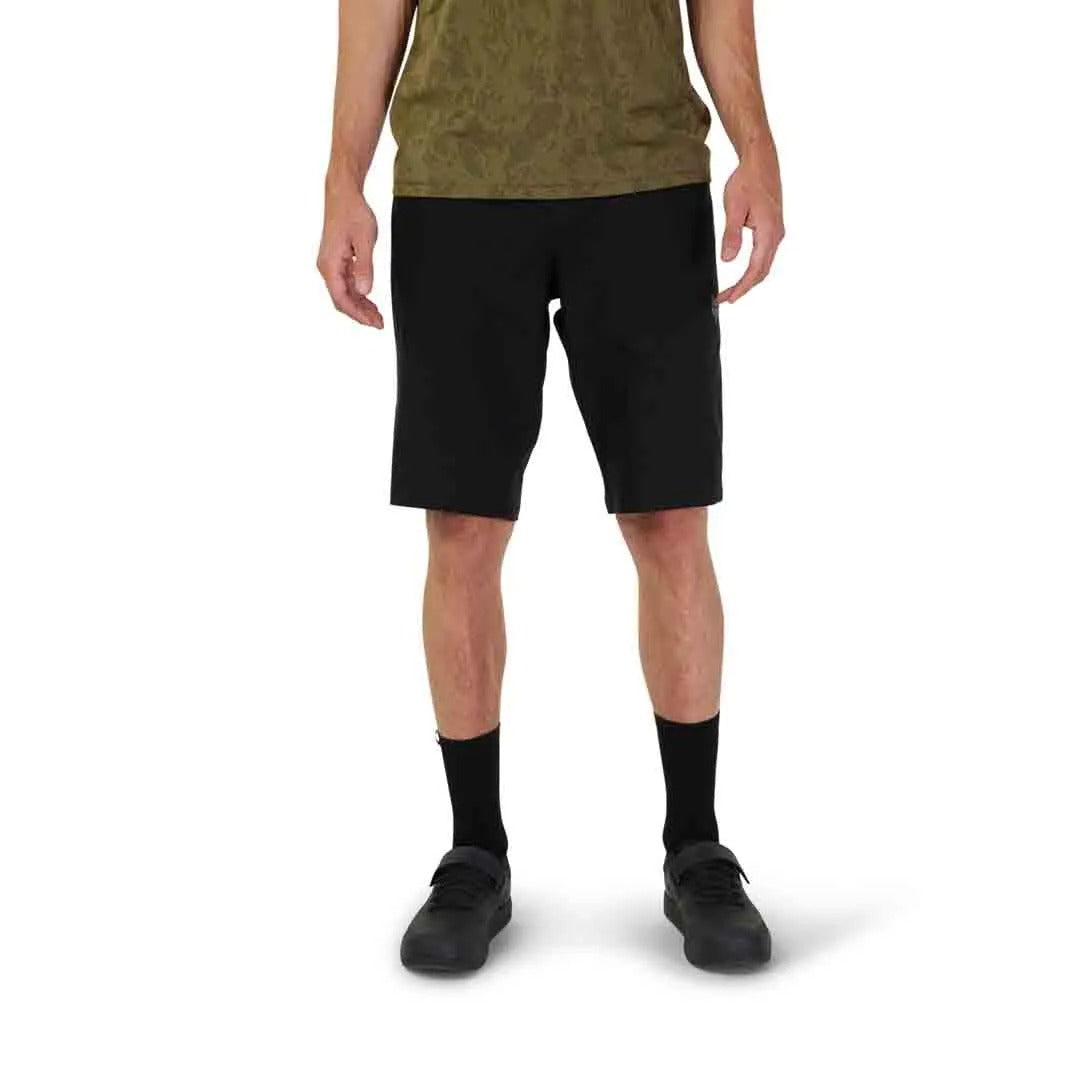 Person wearing black mountain bike shorts on a white background