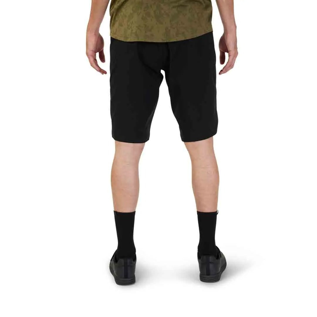 Person wearing black mountain bike shorts on a white background