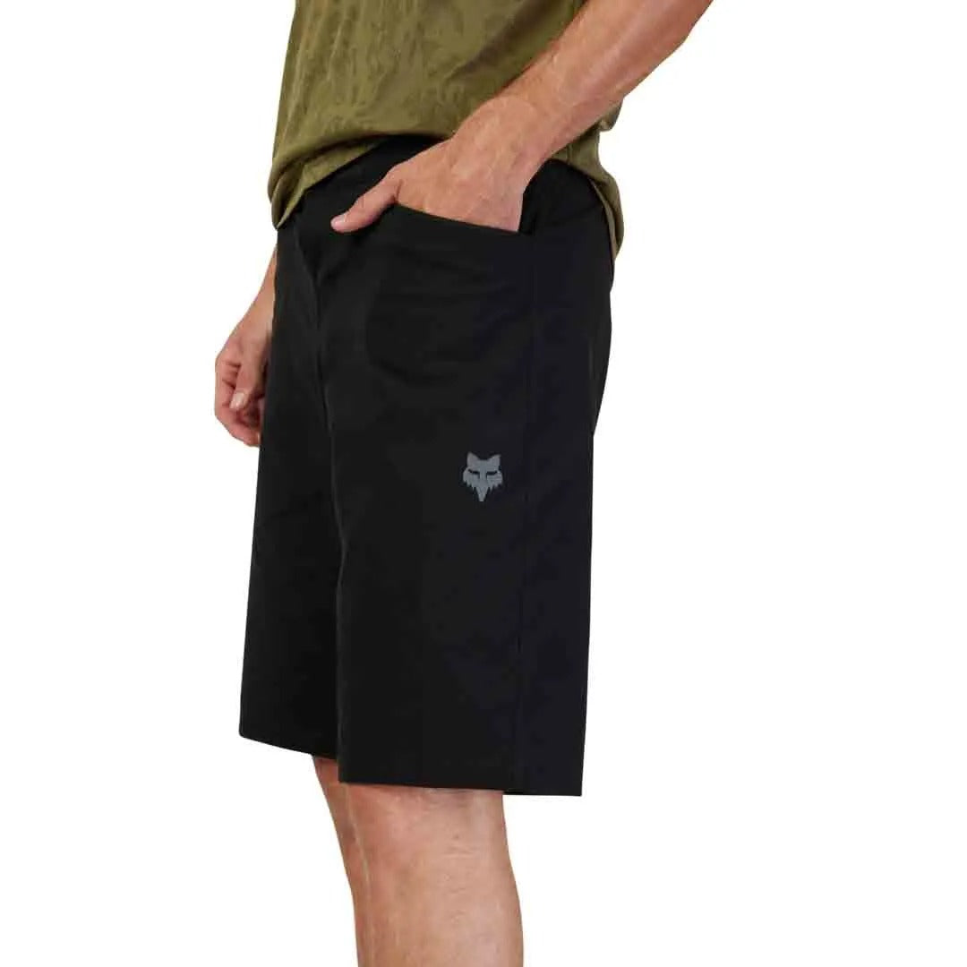 Person wearing black mountain bike shorts with a logo on a white background