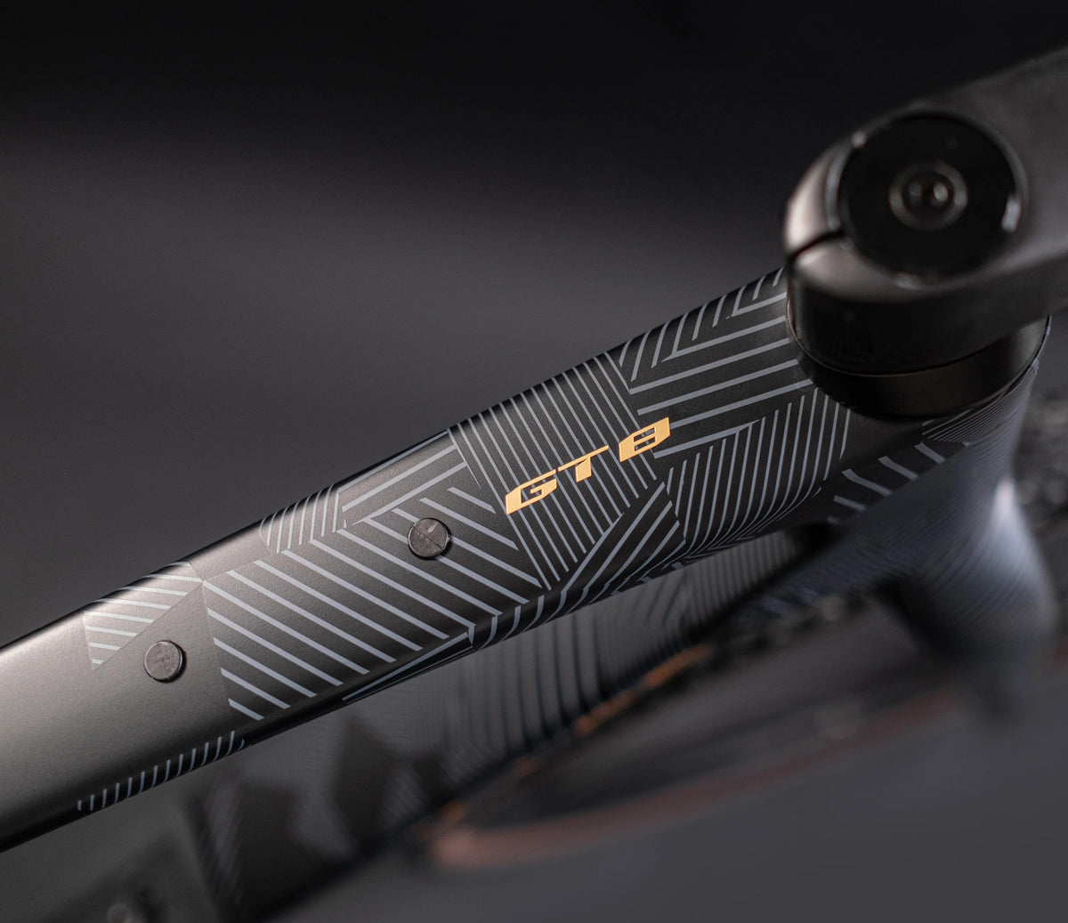 Close-up of a black bicycle frame with 'GT8' branding on a dark background