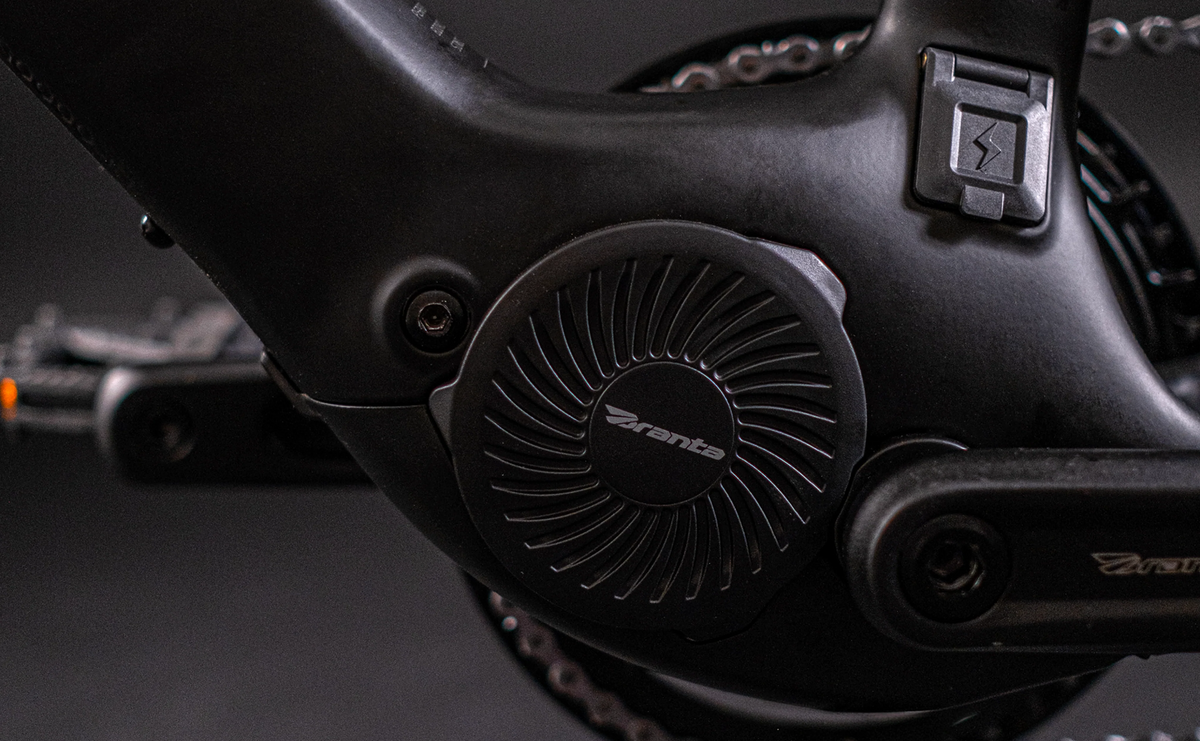 Close-up of a black electronic Branta mid drive motor for an e-bike on a blurred background
