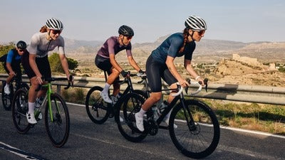 Three cyclists riding on a road with a scenic background
