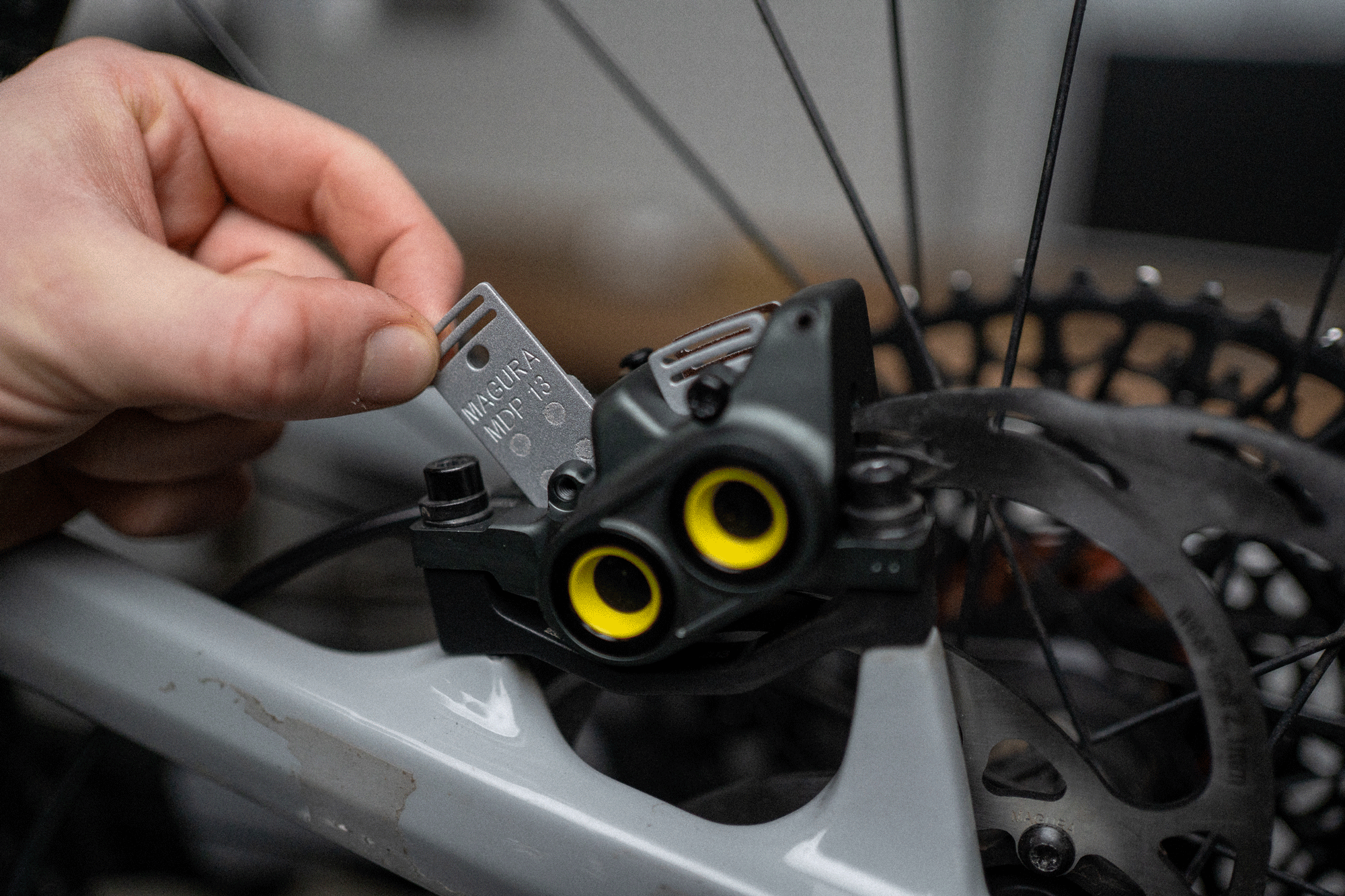 Close-up of a person inserting a bicycle disc brake pad.