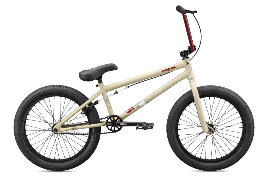 A Mongoose Legion L80 Freestyle BMX bike in beige color with black handlebars and wheels, featuring a chromoly frame and steel fork.