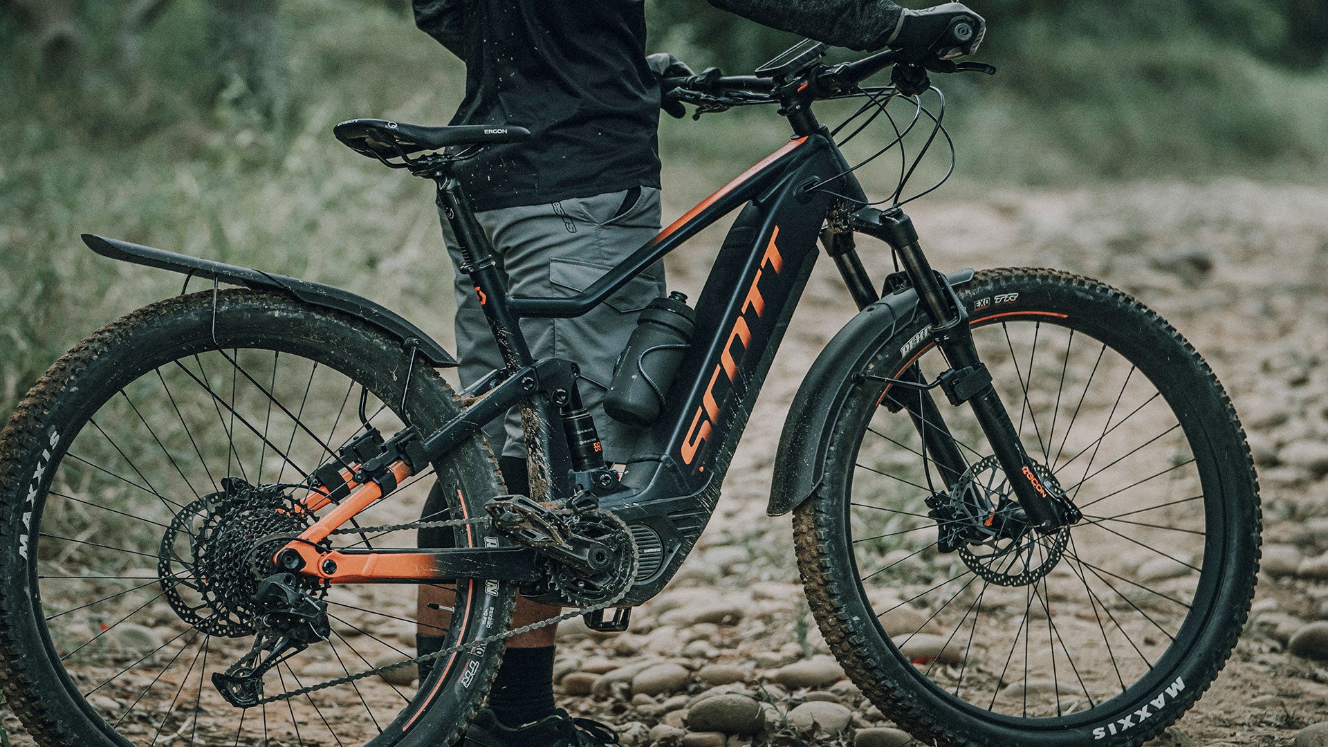 A picture of someone holding a mountain bike with the Topeak Tetrafender M1 / M2 Set MTB Fork/Stay Mount Mudguards mounted to the bike