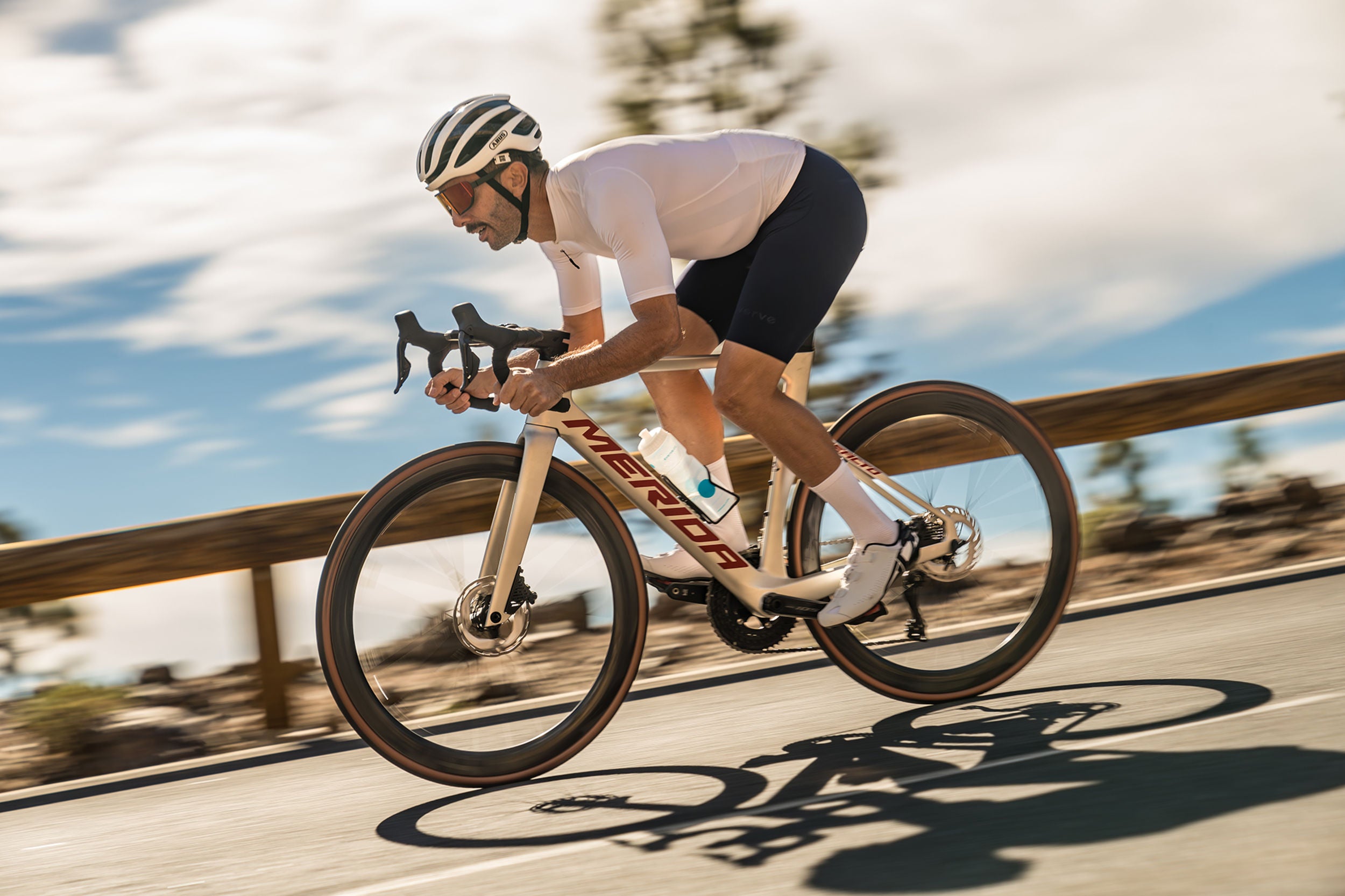 A picture of a man riding downhill on a Merida Road Bike