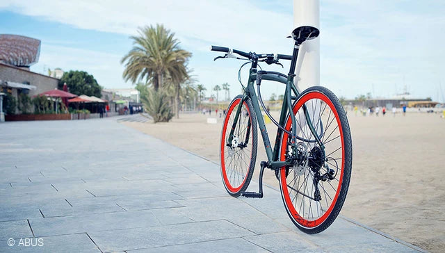 A picture of a bicycle locked to a pole with the ABUS Primo Coil Lock