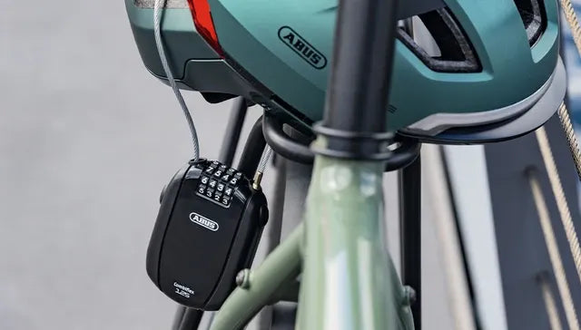 Green bicycle with a helmet and ABUS lock on a blurred background