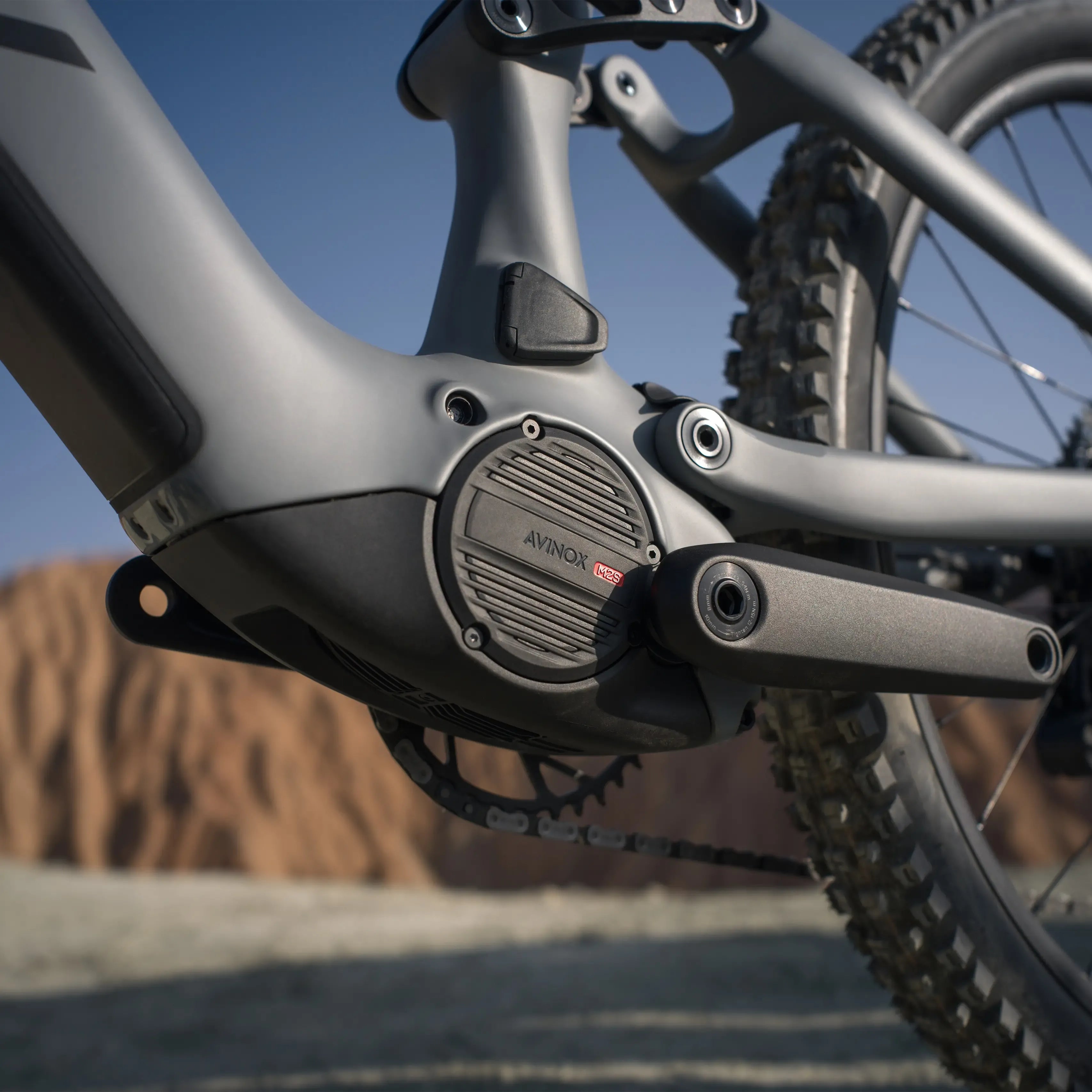 Close-up of a Avinox drive unit on an electric bicycle against a blurred natural background