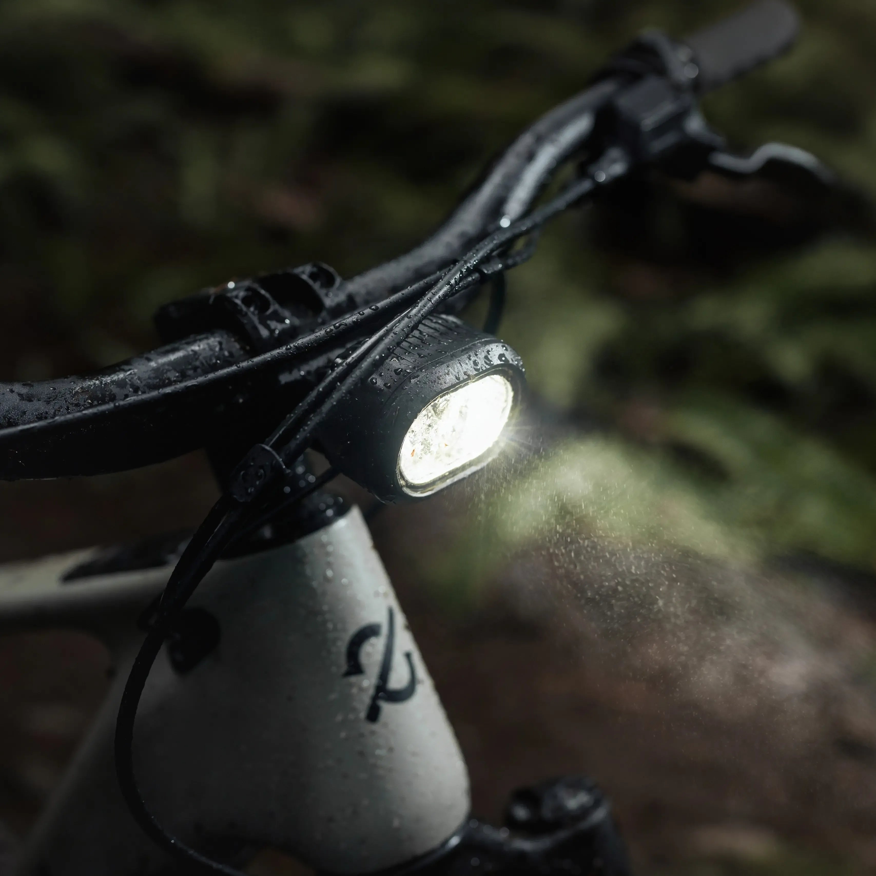 Bicycle headlight on handlebars with a blurred natural background