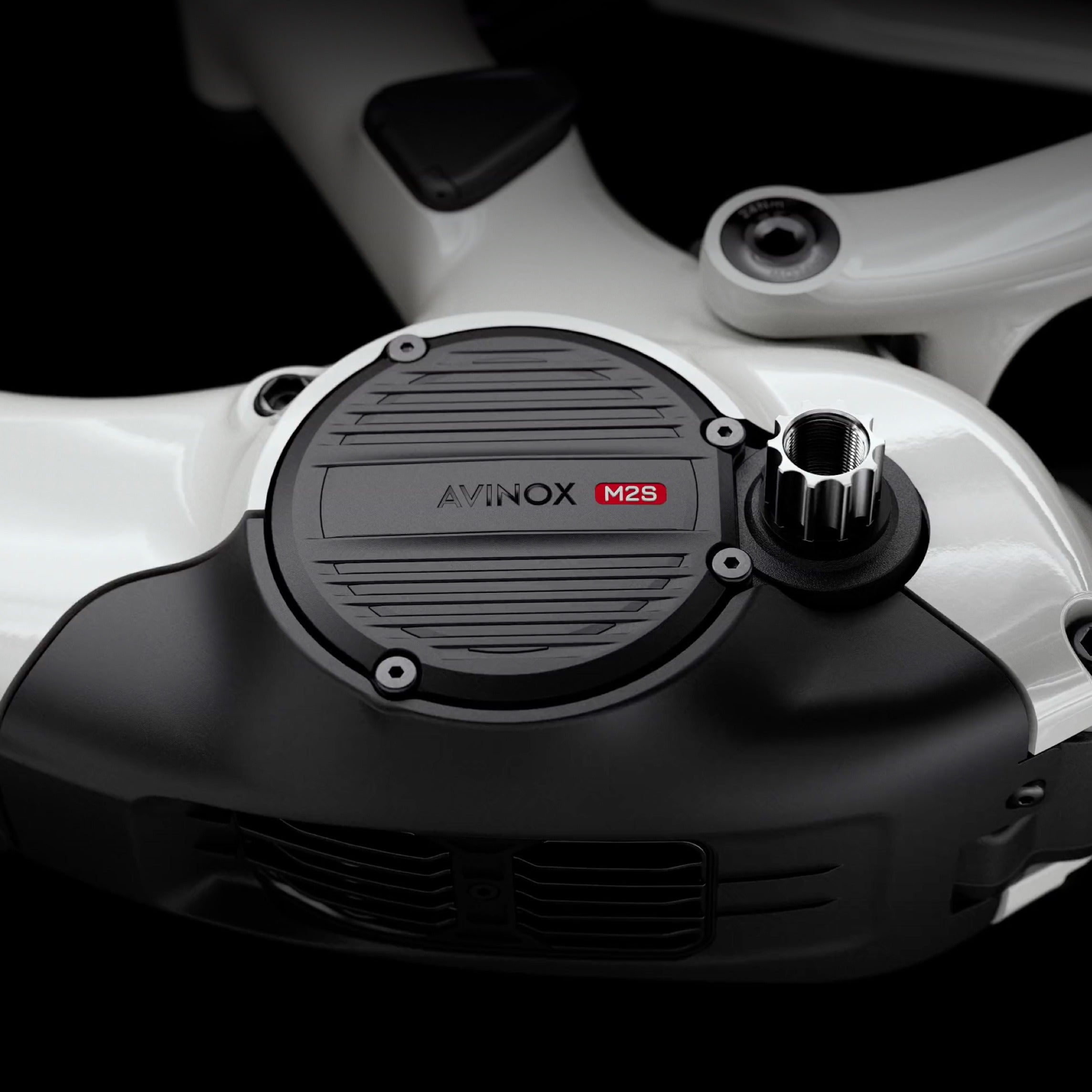 Close-up of a mid drive motor on an electric mountain bike with 'AVINOX' branding on a dark background