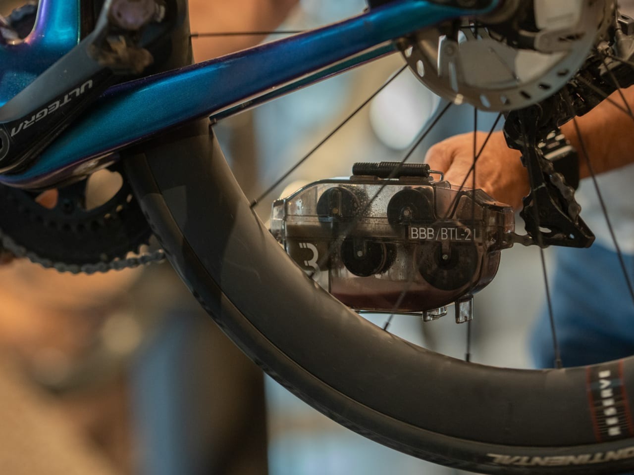 Close up of someone using a BBB Chain Cleaner Tool on a bike chain
