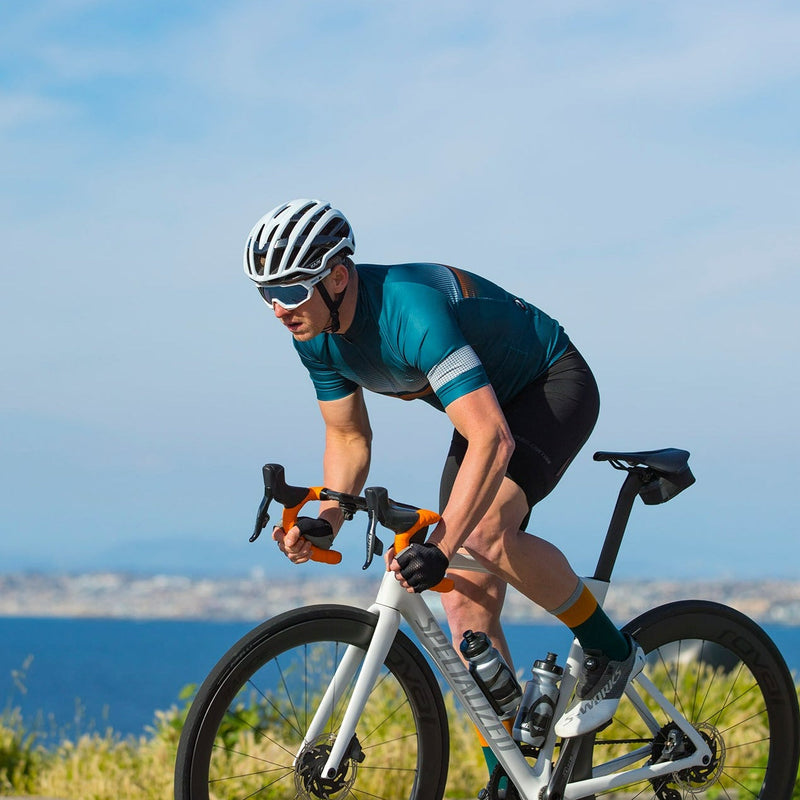 A picture of a man riding a road bike wearing a Bellwether Pinnacle Cycling Jersey