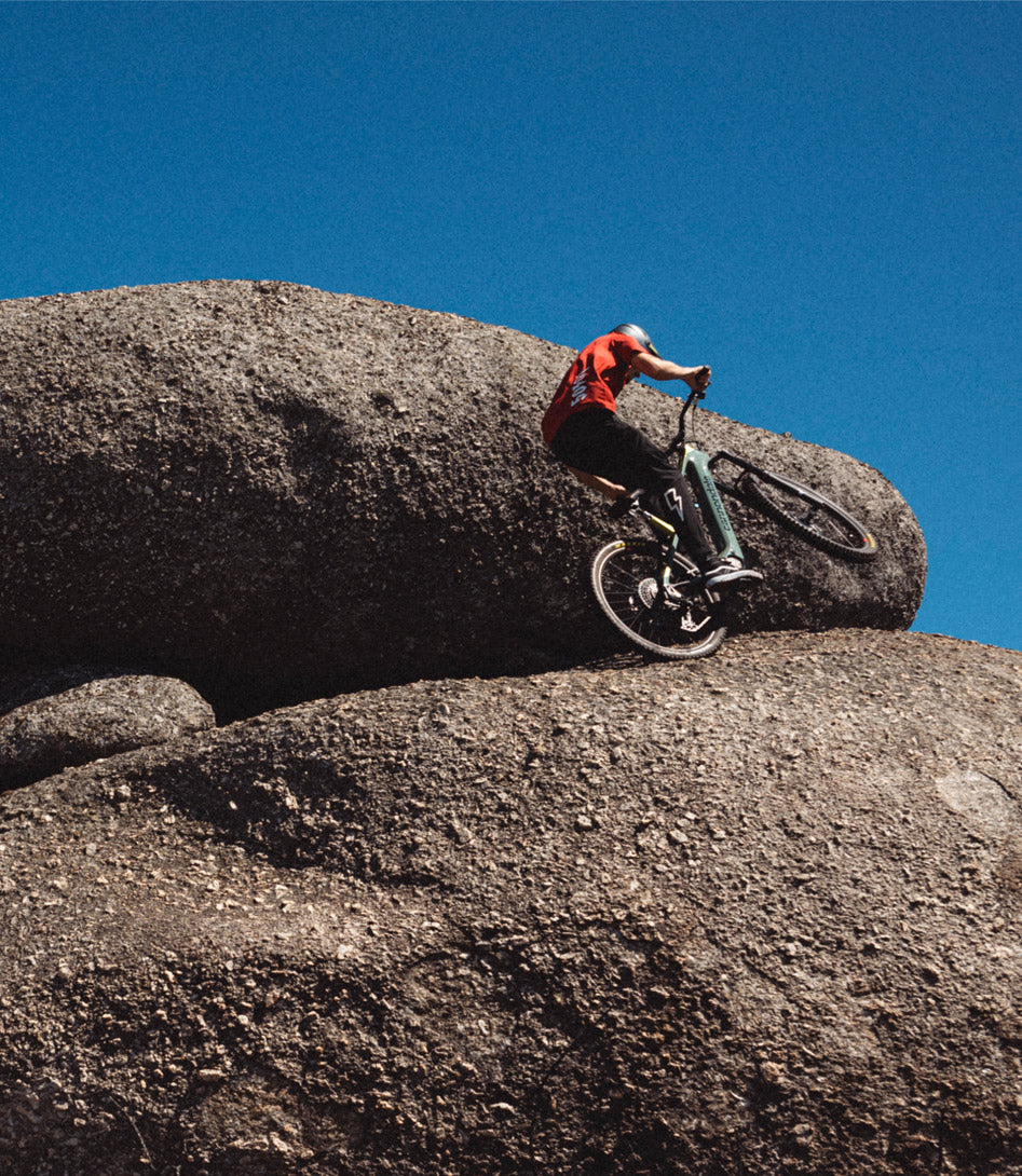 A picture of a guy on the Cannondale Moterra Neo 4 Dual Suspension E-Mountain Bike riding on a rock