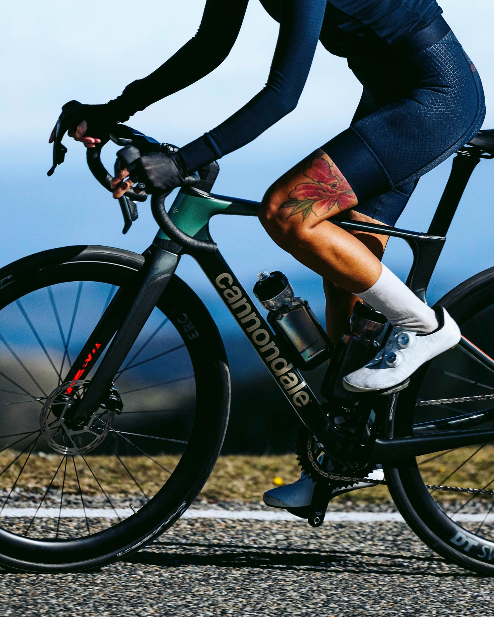 Person riding a Cannondale road bike on a road with a blurred background