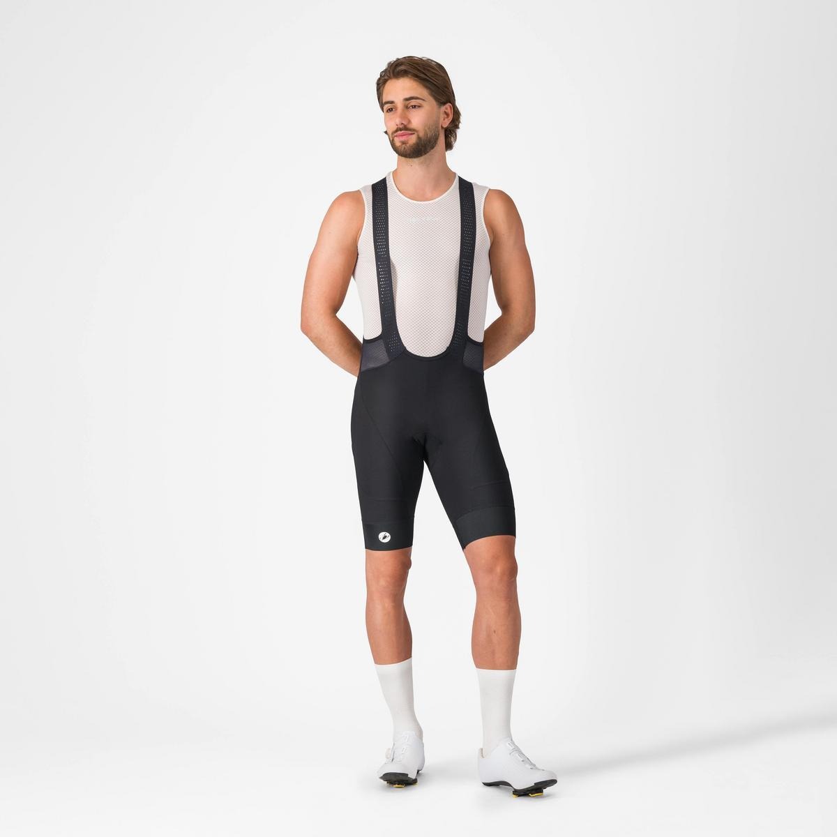 A man wearing black cycling bib shorts on a light grey background