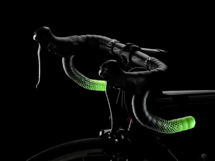 Road Bike handlebar with black and neon green bar tape against a black background