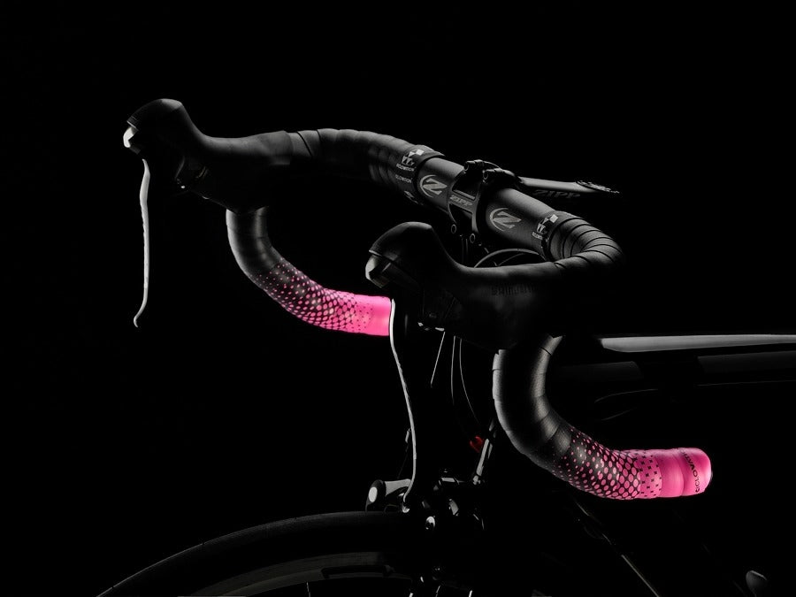 Road Bike handlebar with black and pink bar tape against a black background