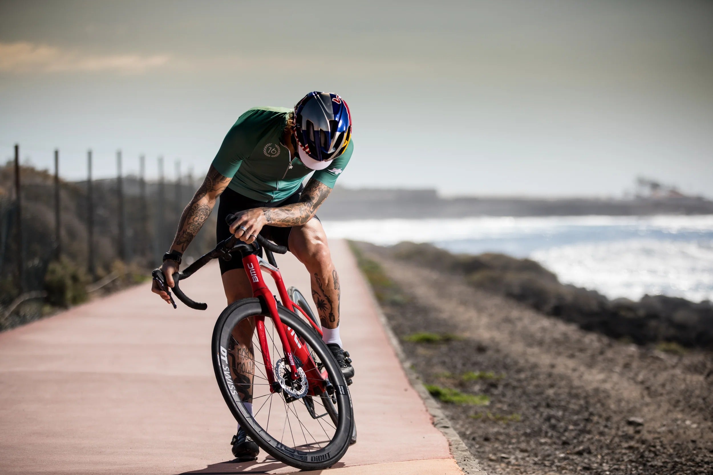 Person cycling on a path by the beach