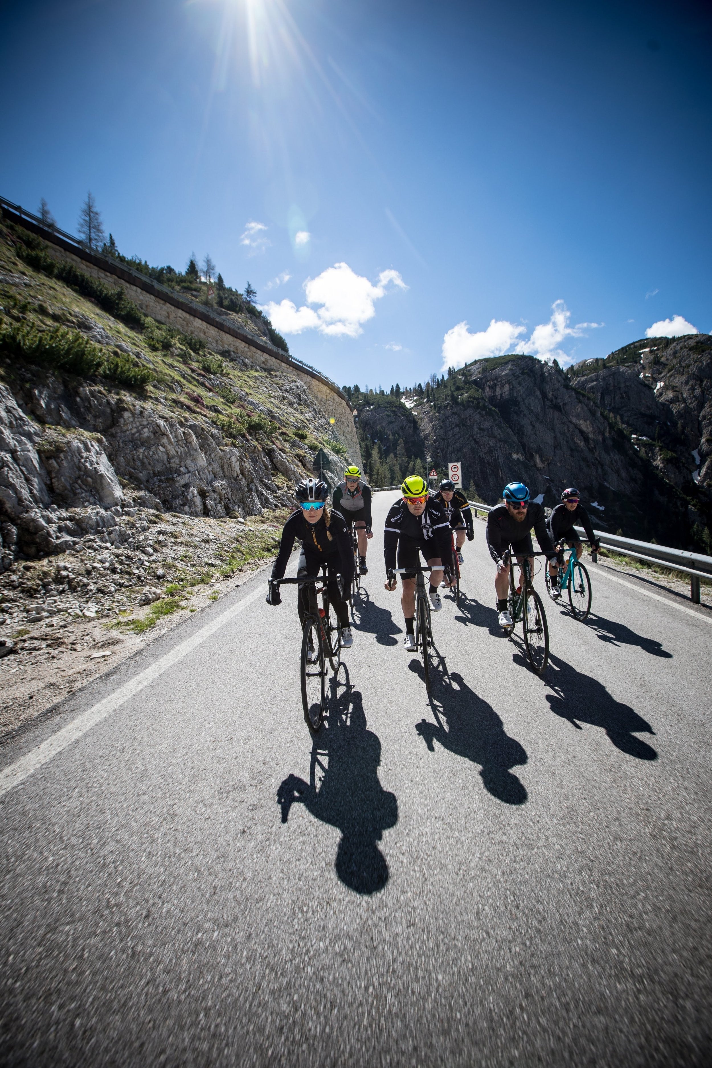 Group of cyclists on a mountain road with a clear blue sky